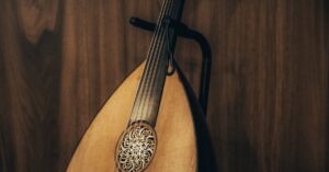A close-up of a traditional oud, showcasing intricate details against a wooden backdrop.